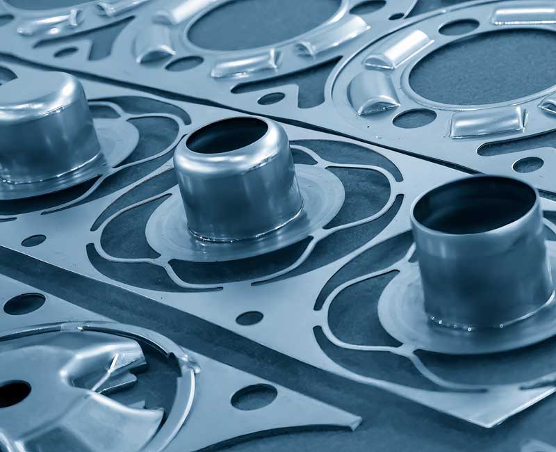 Inset close up showing stacked, formed metal components with clean, uniform bends.