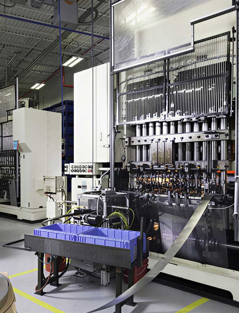 Industrial manufacturing facility with automated metal stamping equipment and material handling systems.