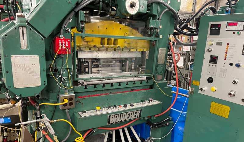 Bruderer high-speed metal stamping press with control panel and tooling in a manufacturing facility.